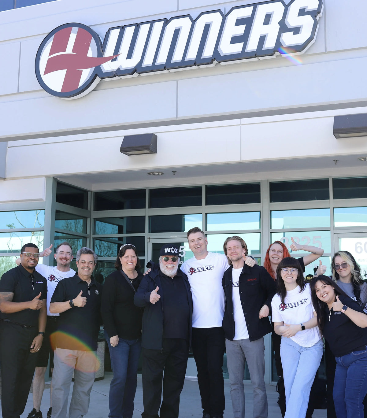 Group of people posing in front of a store with 'Winners' branding.